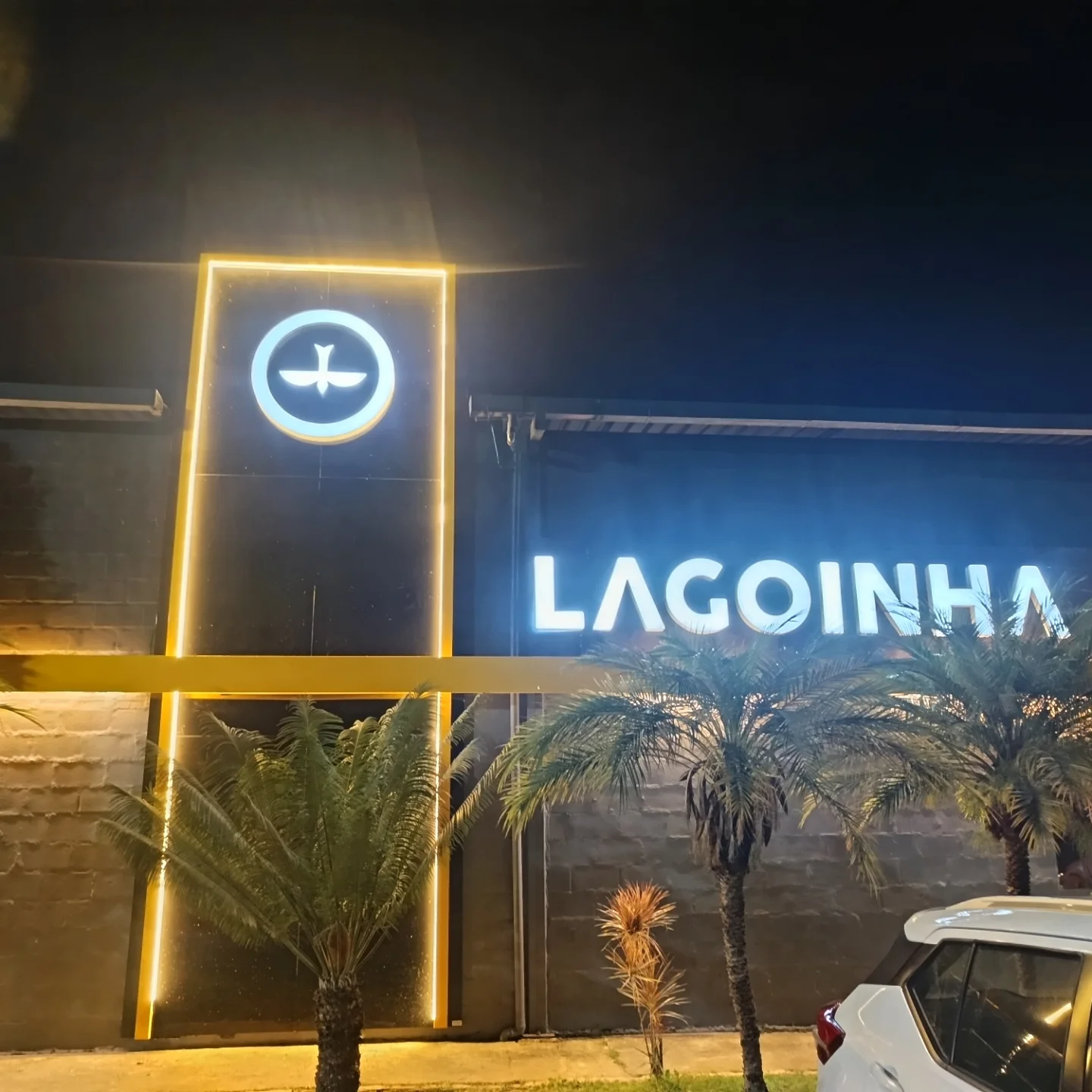 Totem iluminado da Igreja Lagoinha à noite, ao lado da fachada com letra caixa acesa